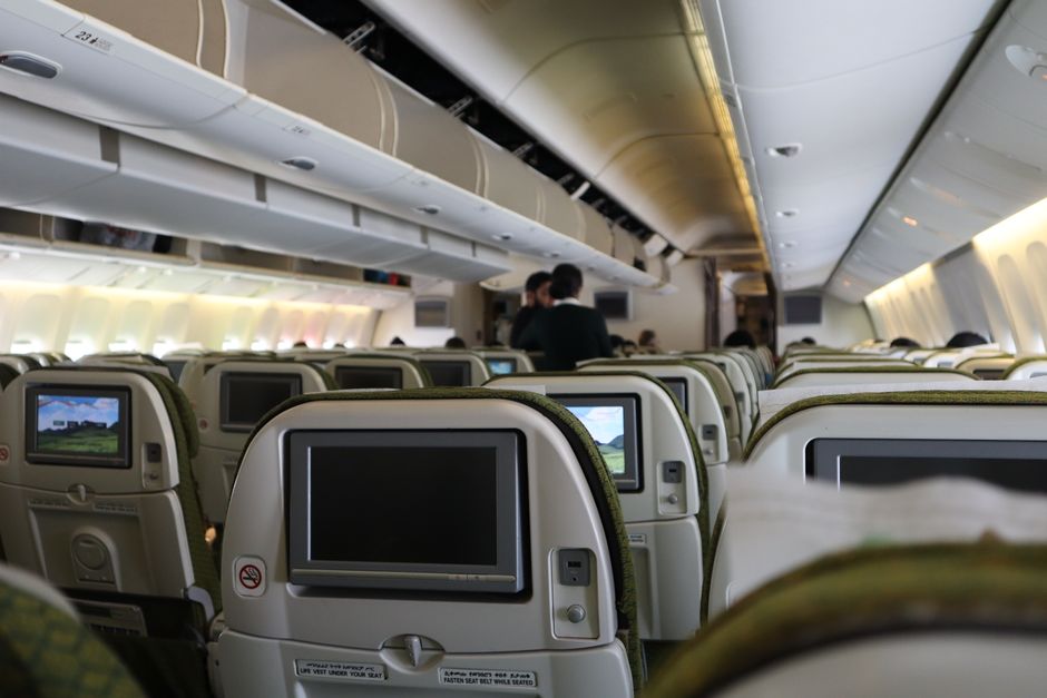 Airplane cabin interior with seats and screens