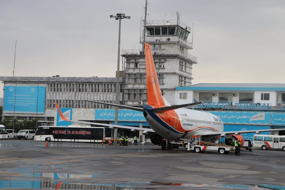 Airplane at Kabul Airport's domestic terminal with visible tower.
