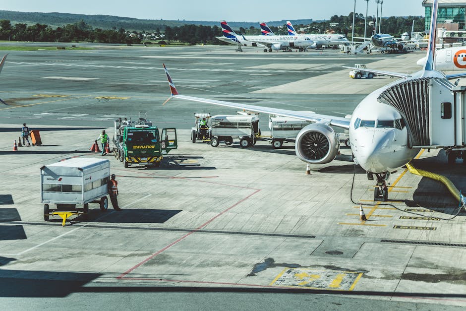 Ground crew preparing a commercial airplane for departure at an airport tarmac.