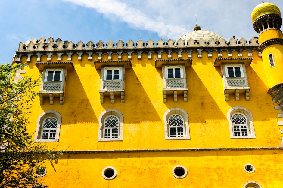 Explore the stunning yellow walls of Pena Palace in Sintra, showcasing unique Portuguese architecture.
