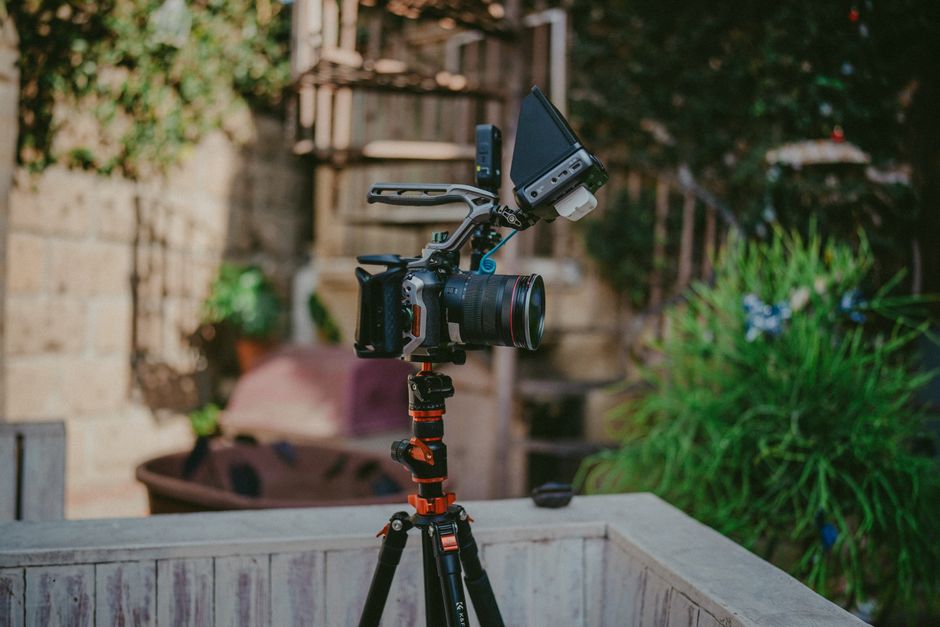 A high-quality camera setup on a tripod outdoors, ideal for professional filming and photography.