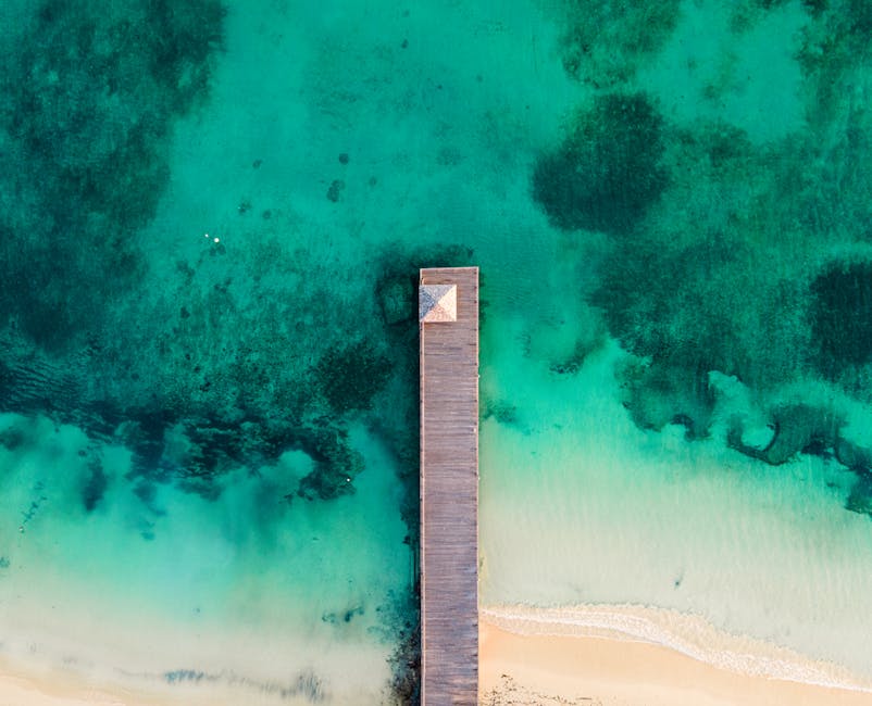 Stunning aerial view of a wooden pier extending into the turquoise waters of Ocho Rios, Jamaica.