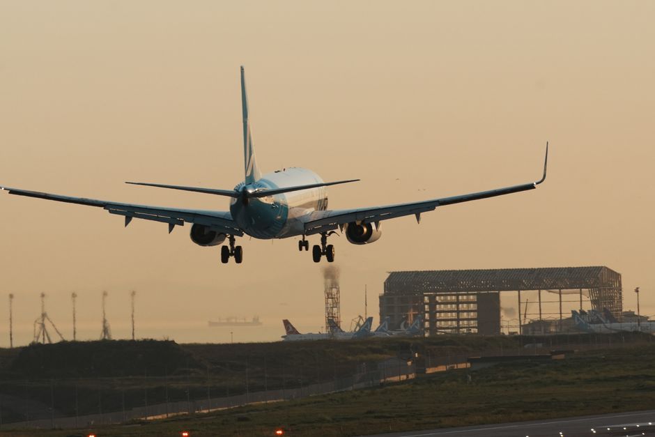 A jet plane makes a smooth landing at Istanbul Airport during sunset, showcasing aviation precision.