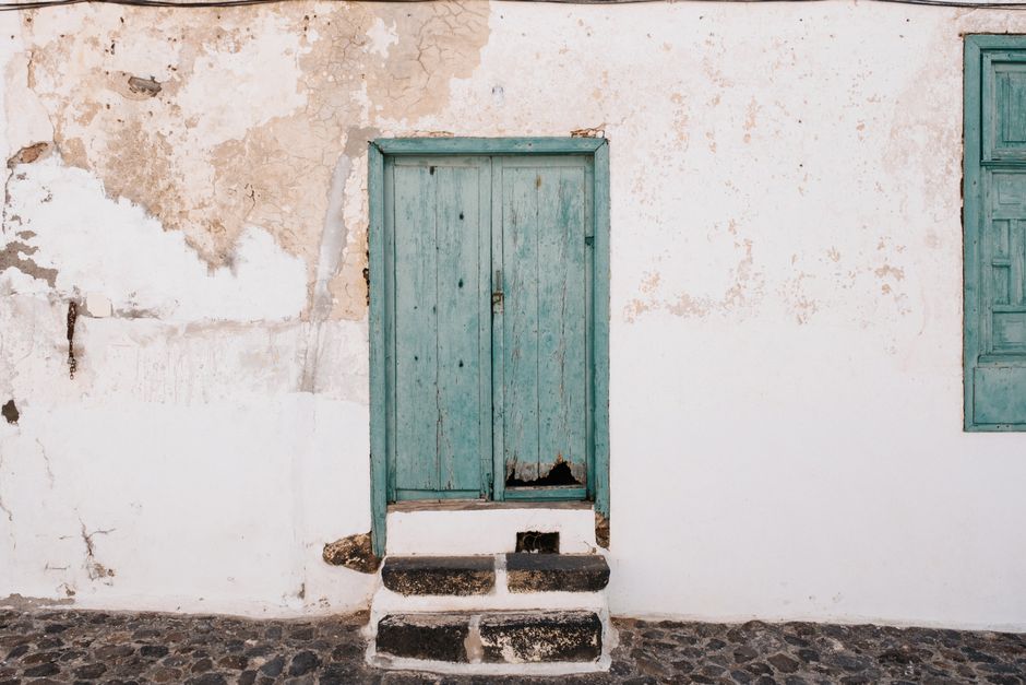 A vintage door in a weathered wall evokes rustic charm and historical ambiance.