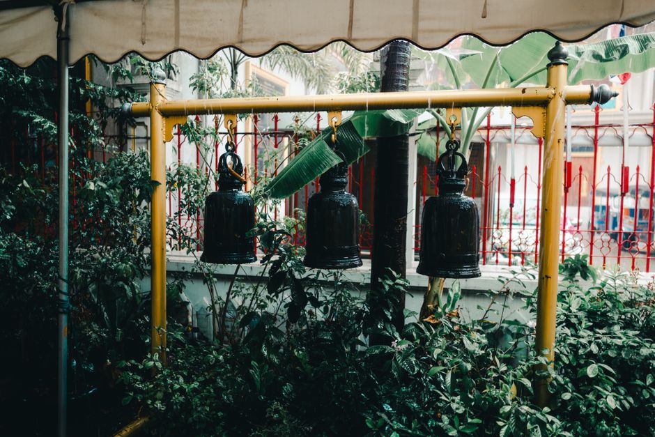 Temple bells in a lush Bangkok garden