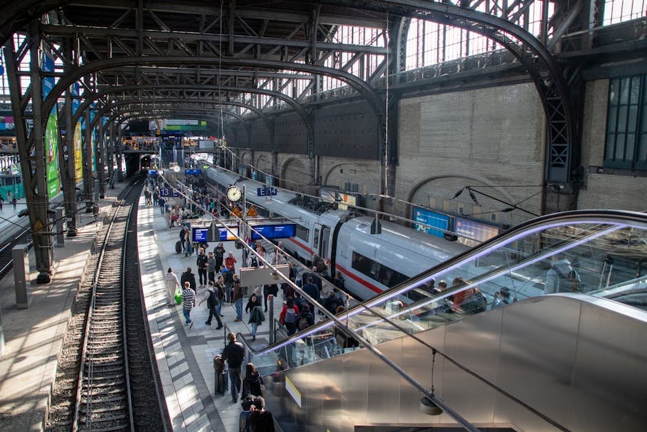 Travelers at Hamburg Central Station boarding a train under architectural arches.
