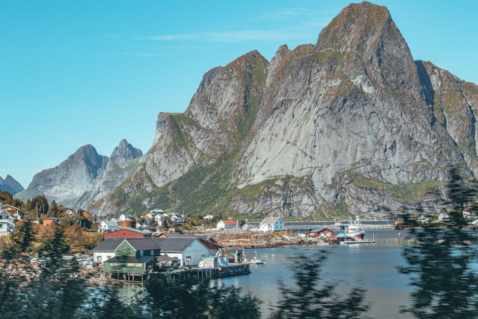 Village by a fjord with towering cliffs Norway