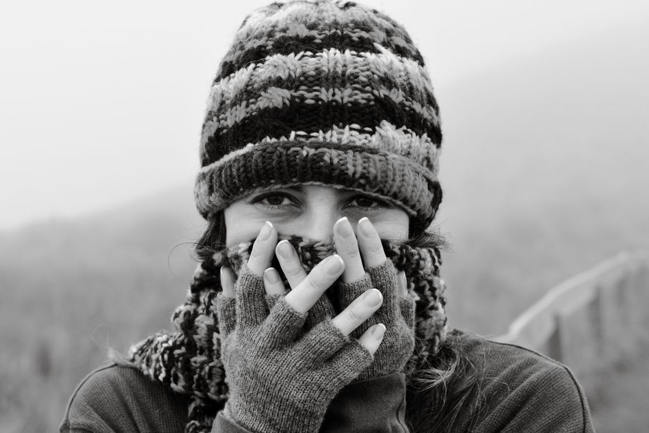 Woman bundled up in winter clothing in the misty Ecuadorian Andes, exuding warmth and coziness.