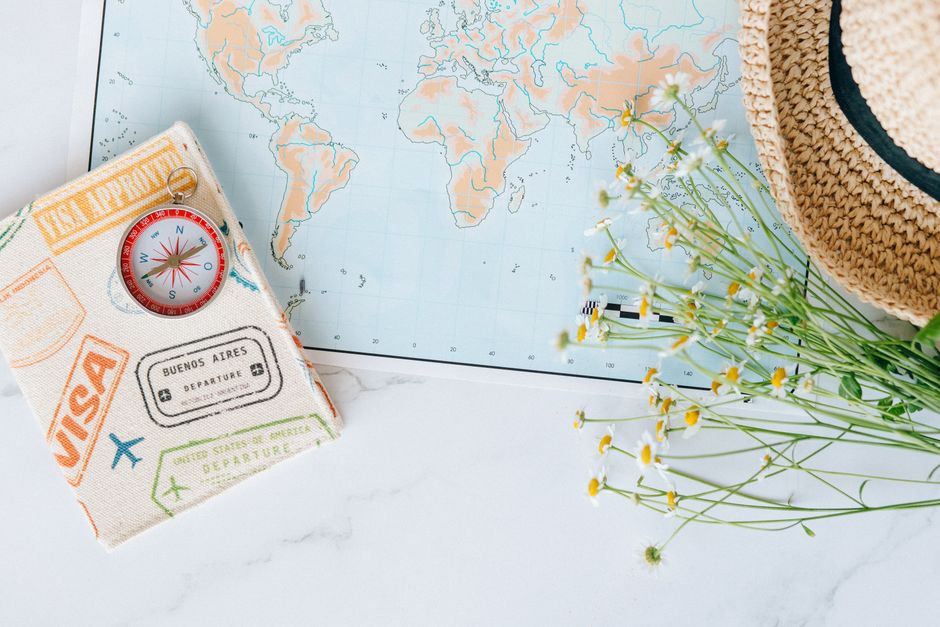 World map compass passport flat lay for trip prep